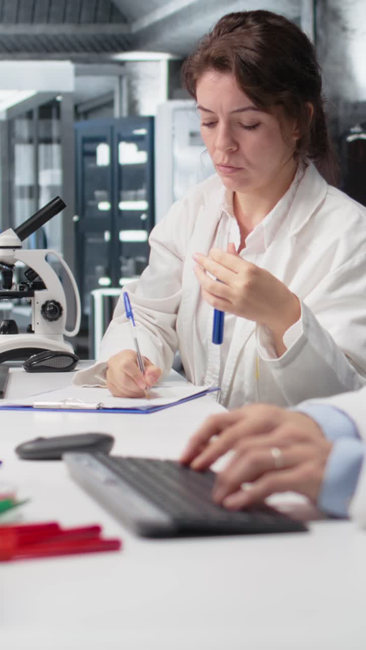 Vertical video Chemical engineer using laboratory glassware with blue indicator solution