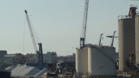 cranes moving sand in a industrial port