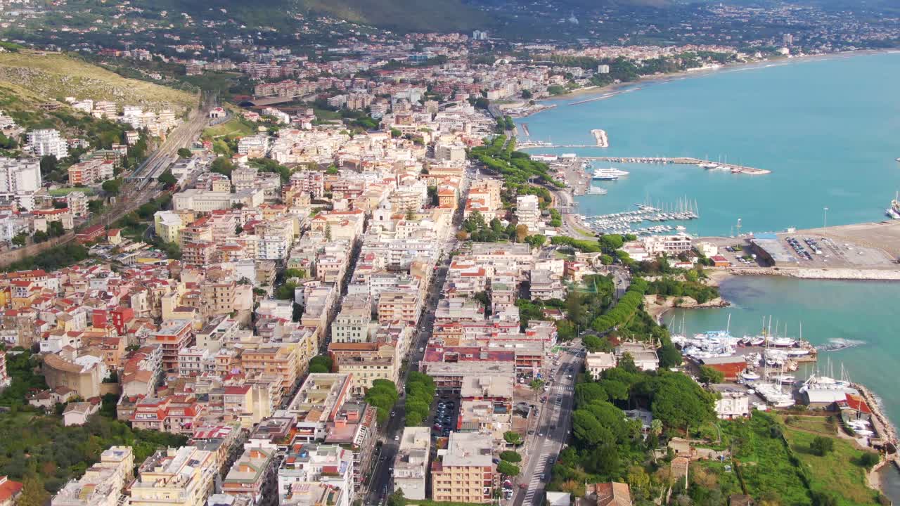 Aerial view of downtown urban seaside Gaeta city buildings and seaport marina, Italy, overhead sideways drone