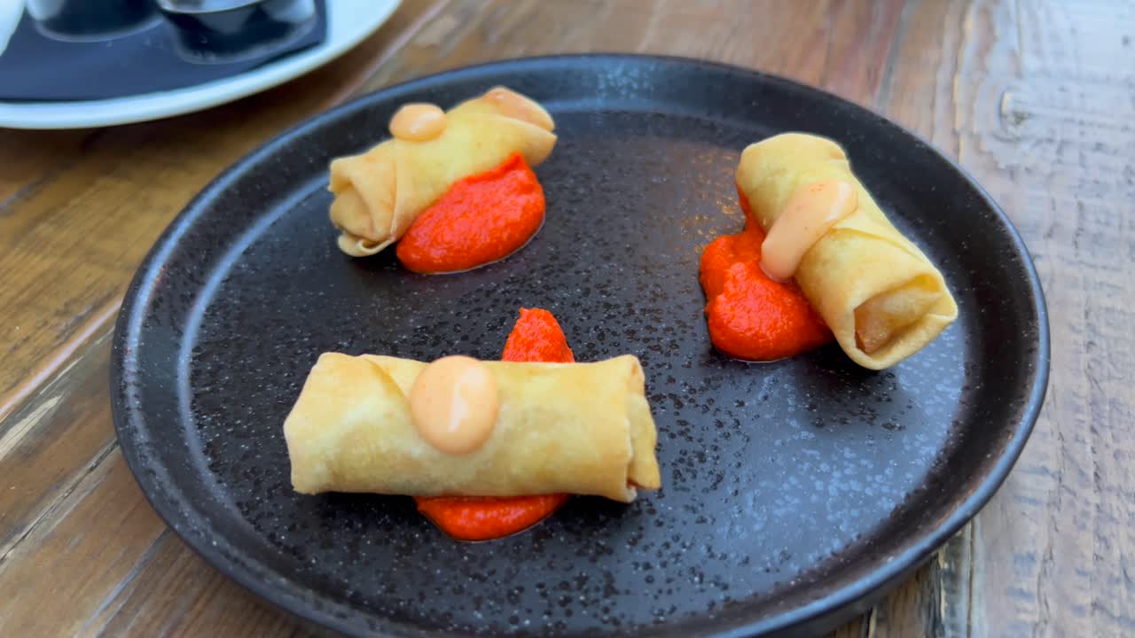 deliciosos rollitos de primavera con salsa picante y mayonesa picante en un restaurante, cocina asiática, tiro de 4k