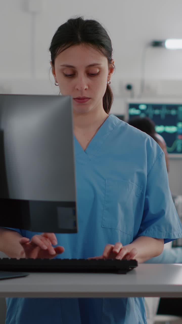 Vertical video: Front view of nurse typing medical expertise on computer