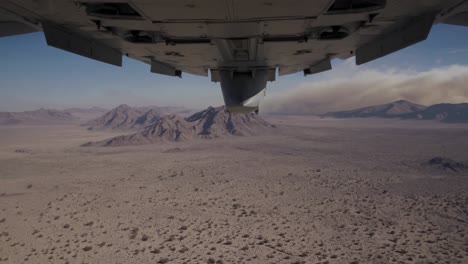 aerial view of desert landscape with mountains and smoke