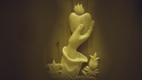 symbol in a wooden church a hand holds an apple and tulips