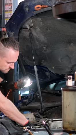 mechanic working on car engine in a garage