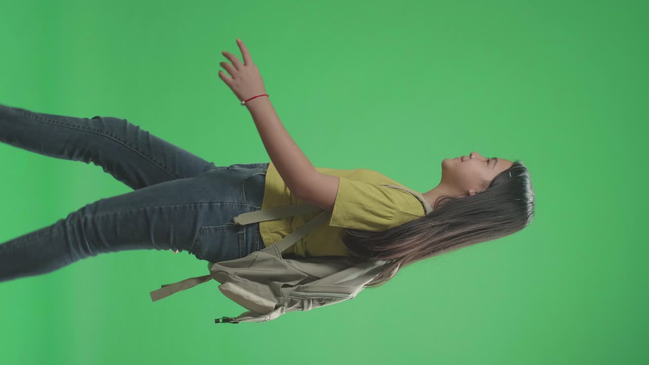 Side View Of Asian Girl Student Walking To School On Green Screen Chroma Key