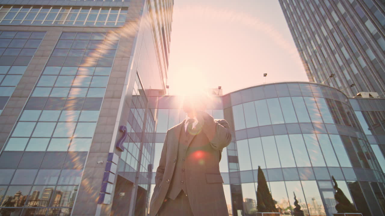 지능형 남자가 도시 빛에서 드폰으로 얘기합니다. 감독이 전화하고 있습니다.