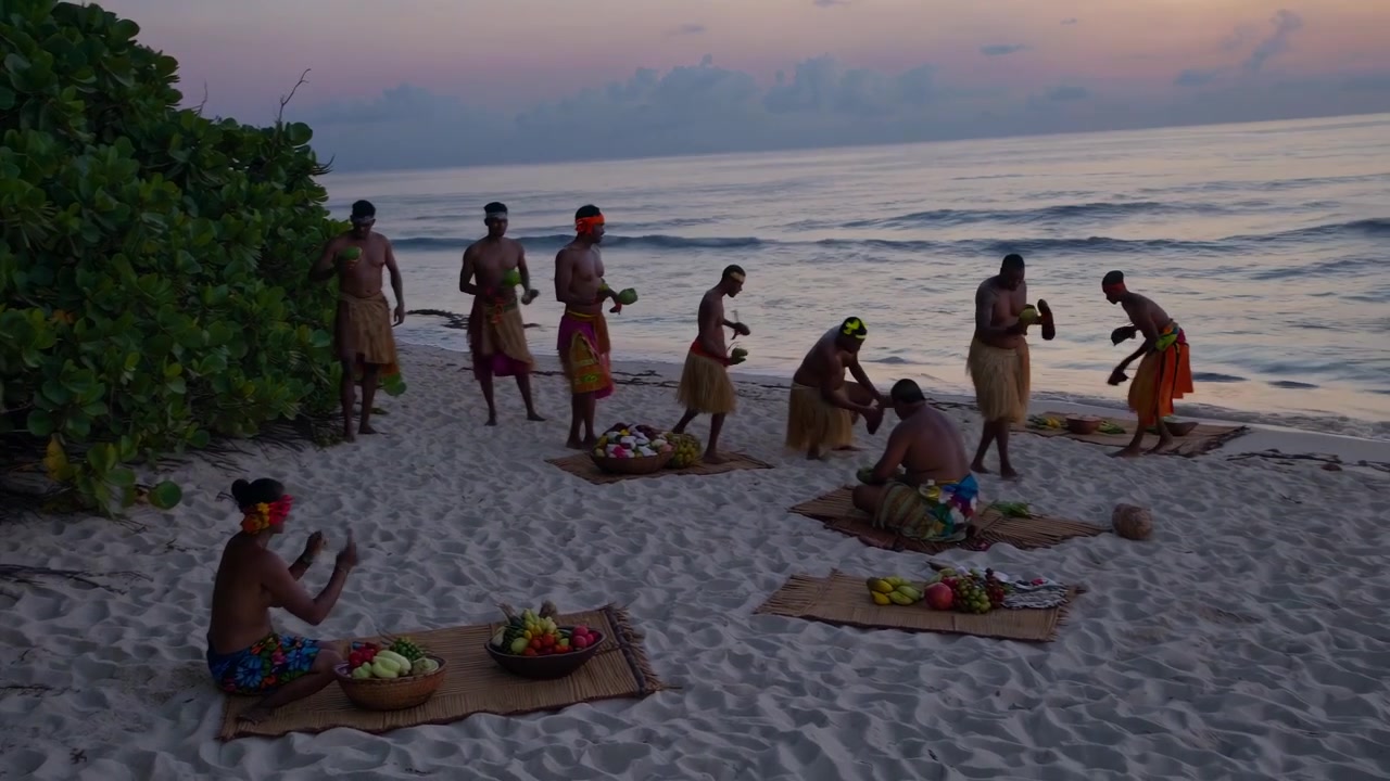 Dançarinos Polinésios Apresentando Dança Tradicional em Praia Tropical ao Pôr do Sol