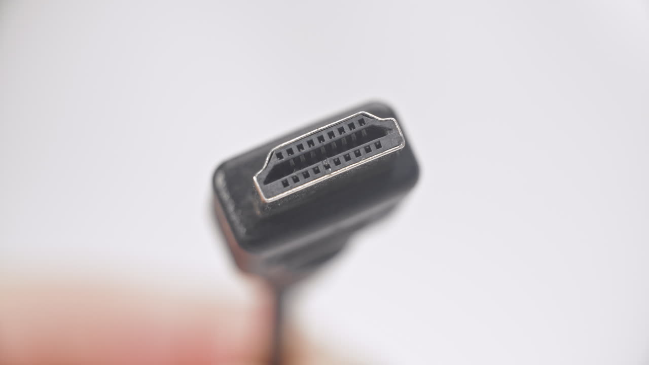 cable hdmi negro en un fondo blanco sostenido en buscadores