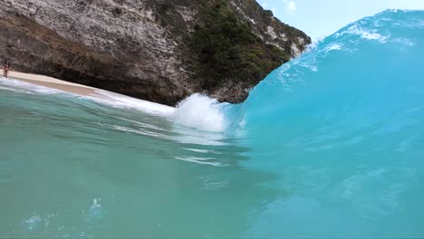 toma en cámara lenta extrema de estar dentro del barril de una gran ola en la playa de kelingking, en la isla de nusa penida, bali, indonesia