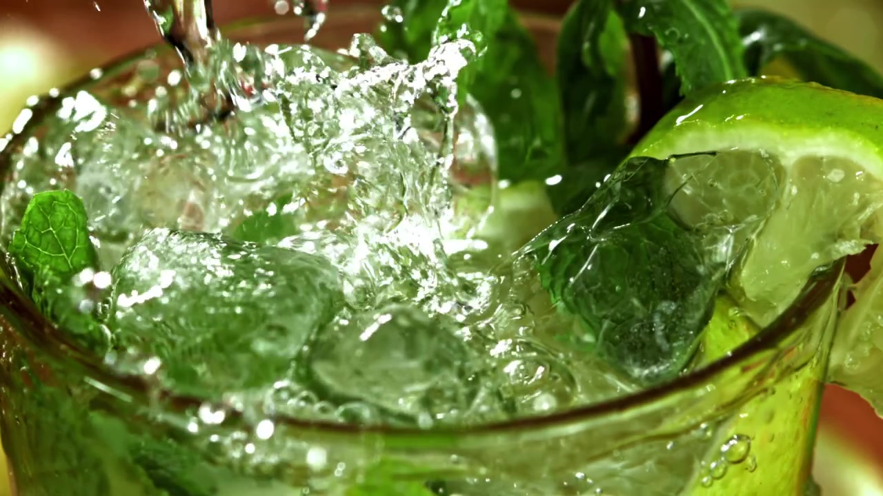 Virkistävää mojito-juomaa jäällä, mintulla ja limellä kaadetaan.