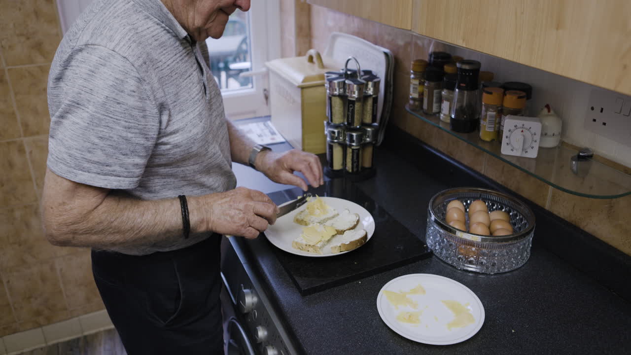 Elderly man making sandwiches in kitchen