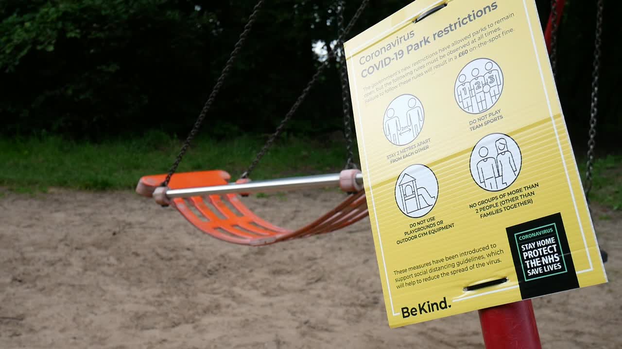 놀이터 스윙 슬로우 모션 옆에 있는 근접 촬영 공공 공원 covid 코로나 바이러스 경고 표시