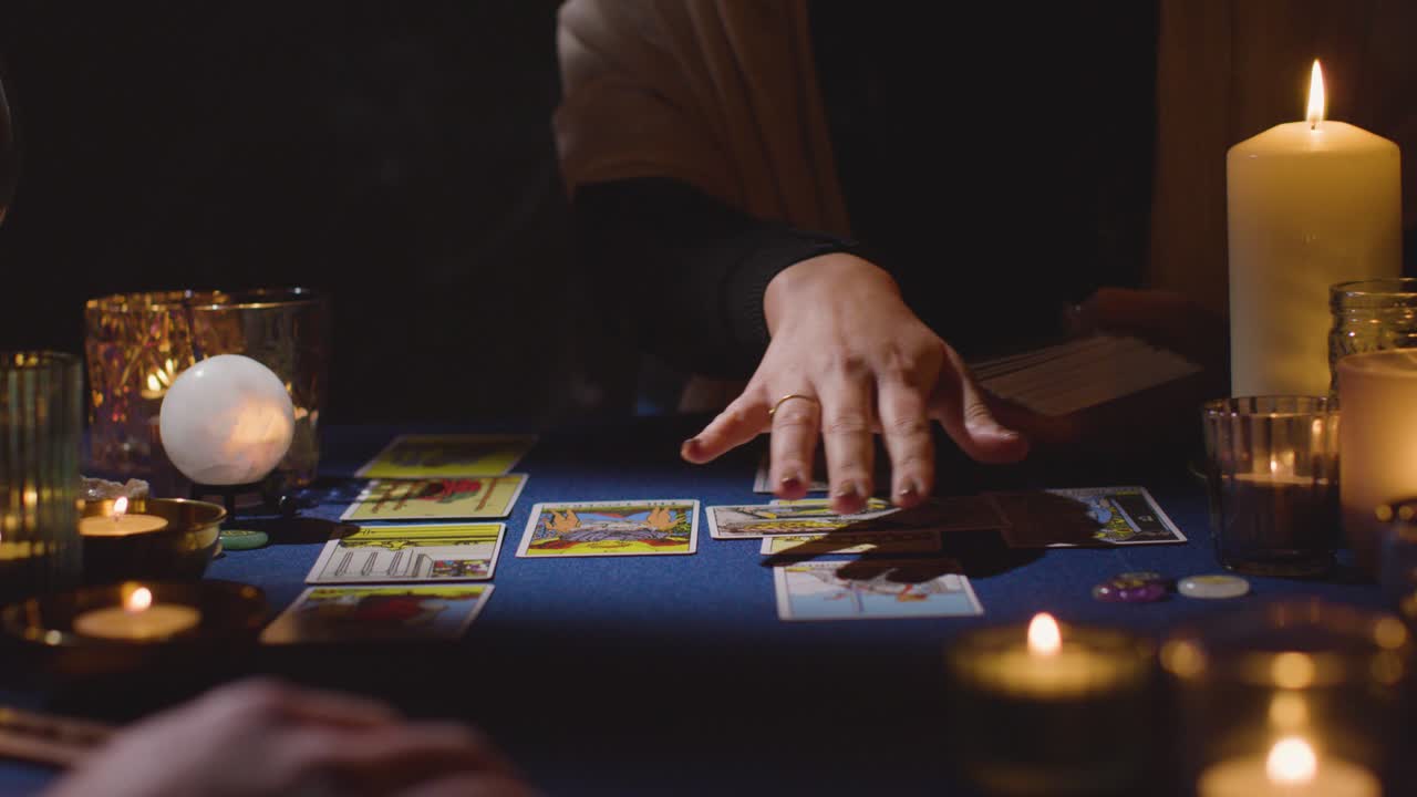 primer plano de una mujer dando una lectura de cartas de tarot a un hombre en la mesa a la luz de las velas 5