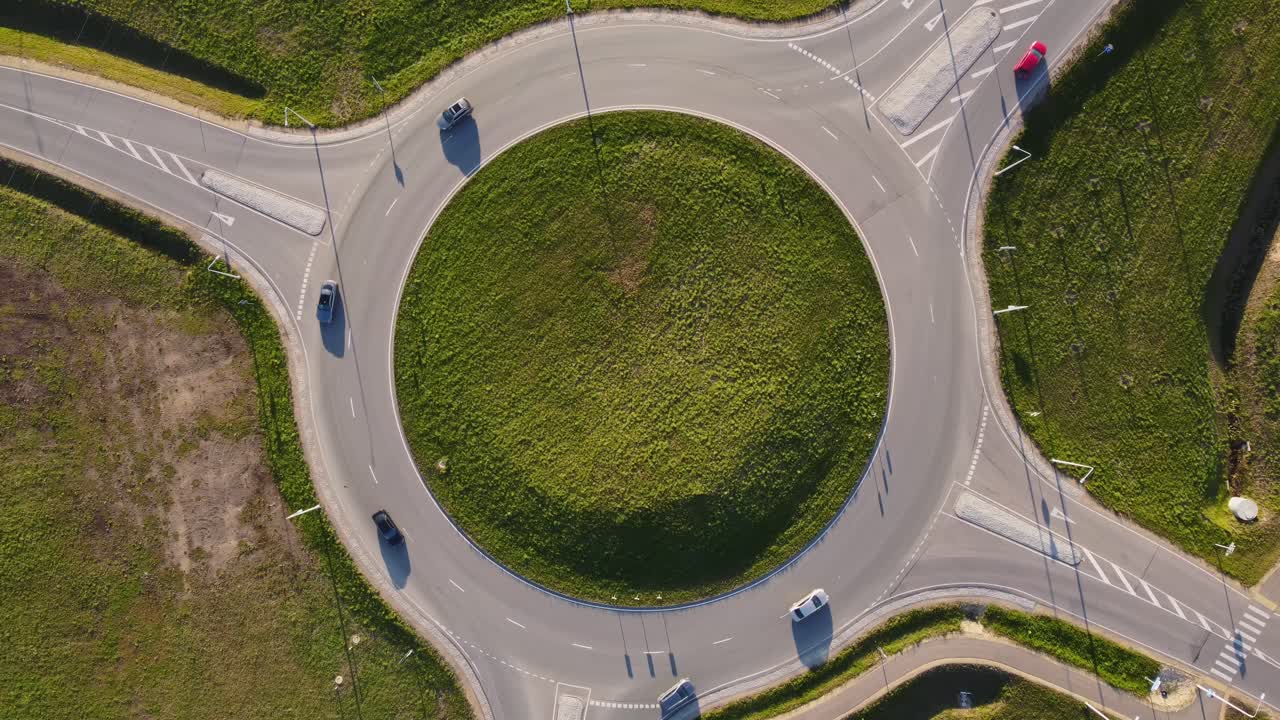 Top down view of cars flowing through roundabout in sunny weather and clear light