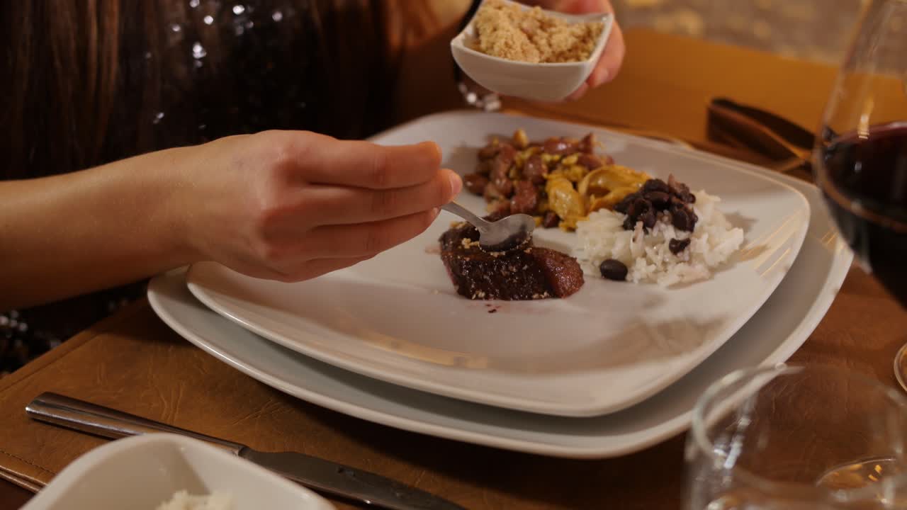 Churrascaria - The hand of a girl puts salt on a piece of meat at a brazilian fine restaurant
