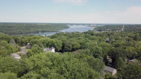 drone rising up above trees to reveal st croix river and lift bridge