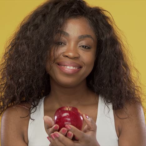 mujer positiva compartiendo manzana con cámara