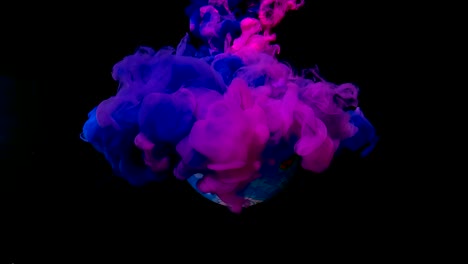 el planeta tierra desde el espacio está girando alrededor de su eje. tinta de acuarela azul y rosa en el agua sobre un fondo negro.