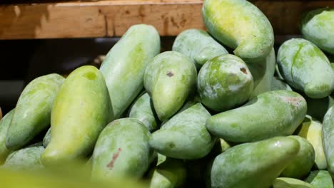 pov to hand grabing fresh mangoes in supermarket