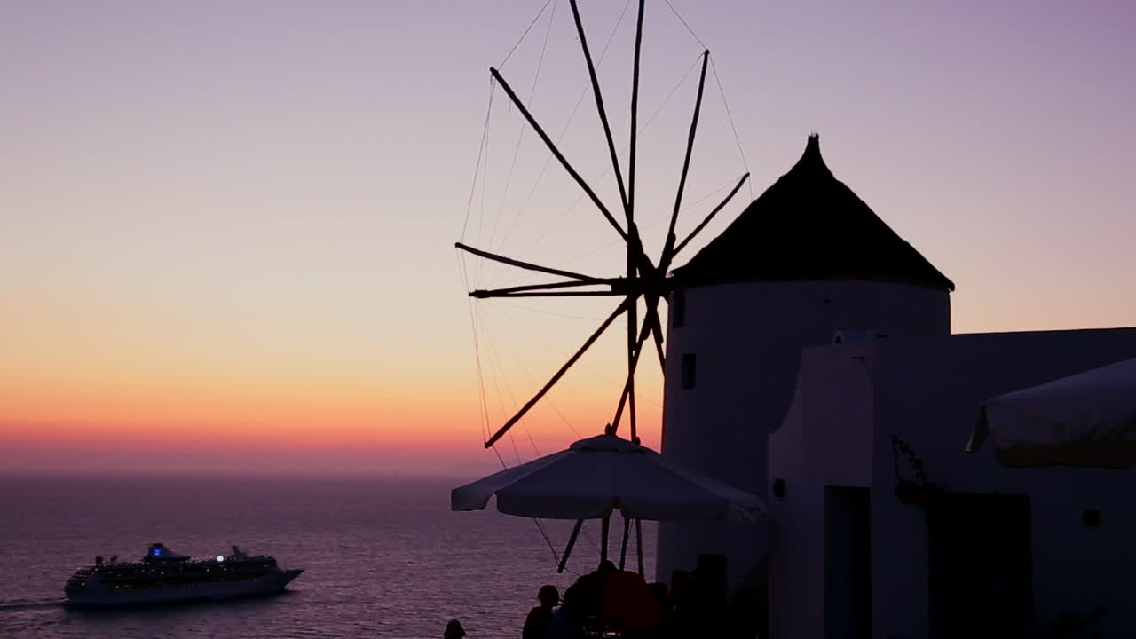 유람선은 황혼 1에 낭만적인 그리스 산토리니 섬에서 황혼이나 일몰에 풍차를 통과합니다.