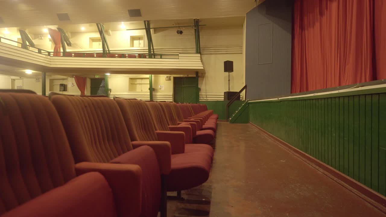 Empty red seats in Thalia Theatre with yellow lights, red curtain