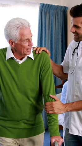 doctor assisting seniorman to walk with walker