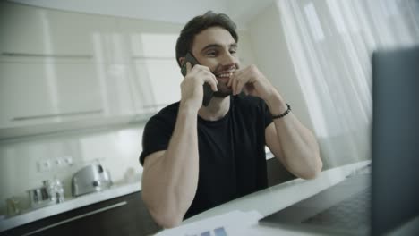 hombre sonriente hablando por teléfono móvil en el lugar de trabajo de casa. hombre de negocios feliz llamada telefónica