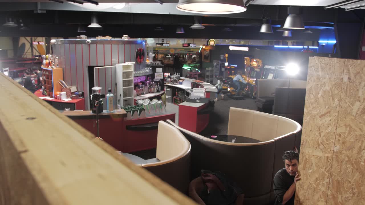 Worker positioning a large wooden panel in an indoor construction area