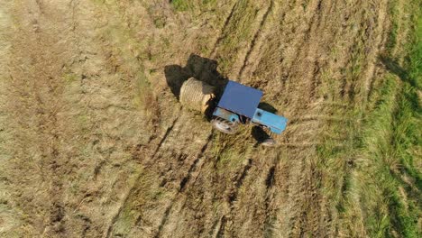 Landwirtschaftliches-Feld-Auf-Dem-Bauernhof-Mit-Traktoren,-Die-Während-Der-Ernte-Heuhaufen-Machen