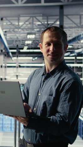 vertical video engineer in data center checks ai dashboard using laptop during systems review