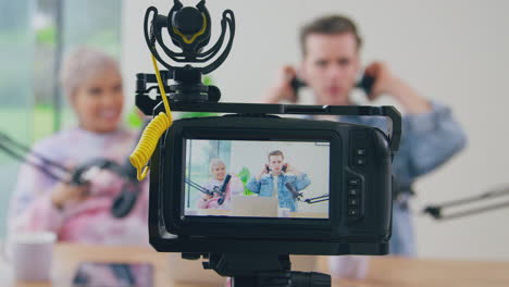 view through camera of couple putting on headphones for vlogging live stream