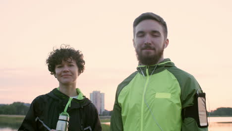 woman and man in sportswear looking at camera outdoors