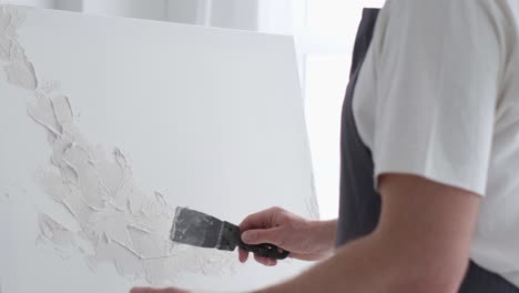 male artist paints a picture with oil paints artist while working in the studio