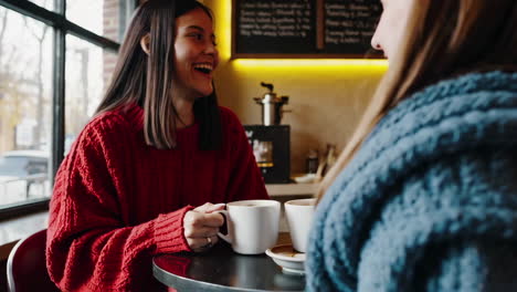 two women friends enjoying coffee in a cafe