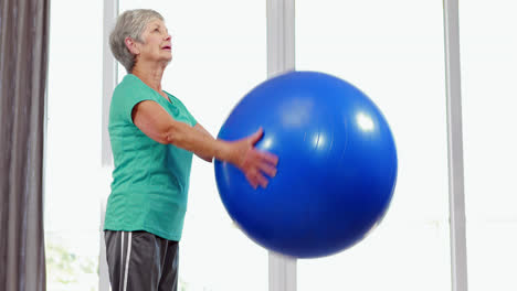 Mujer-Mayor-Levantando-Pelota-De-Ejercicio