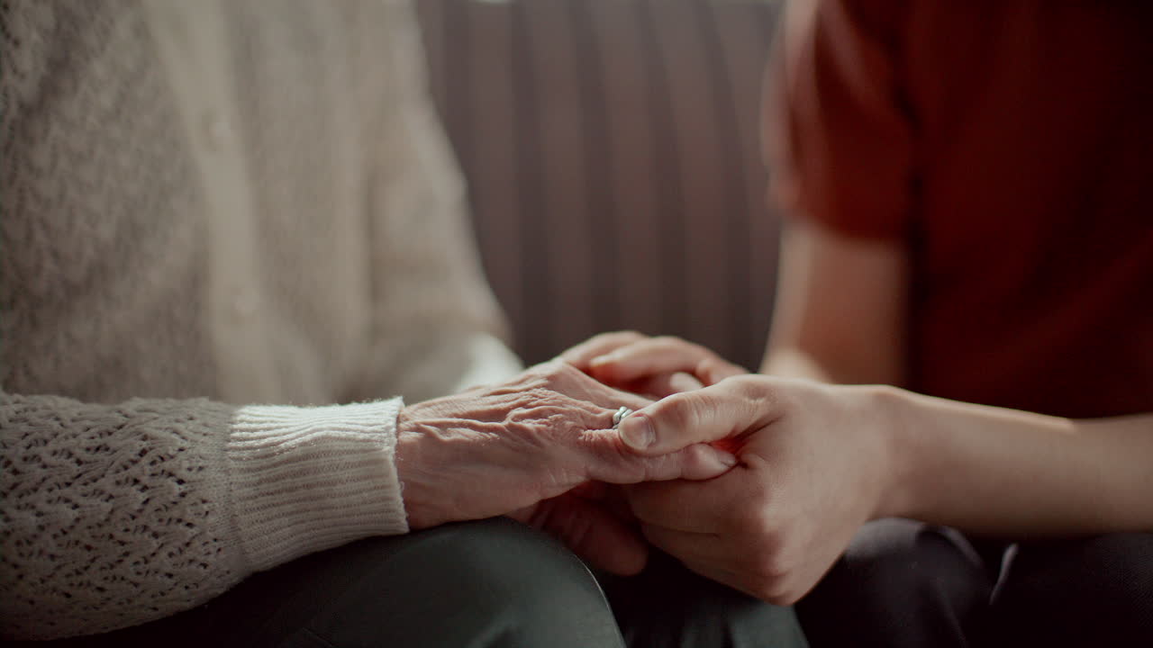 Close-Up of Caring Woman Holding Hands of Elderly Grandmother