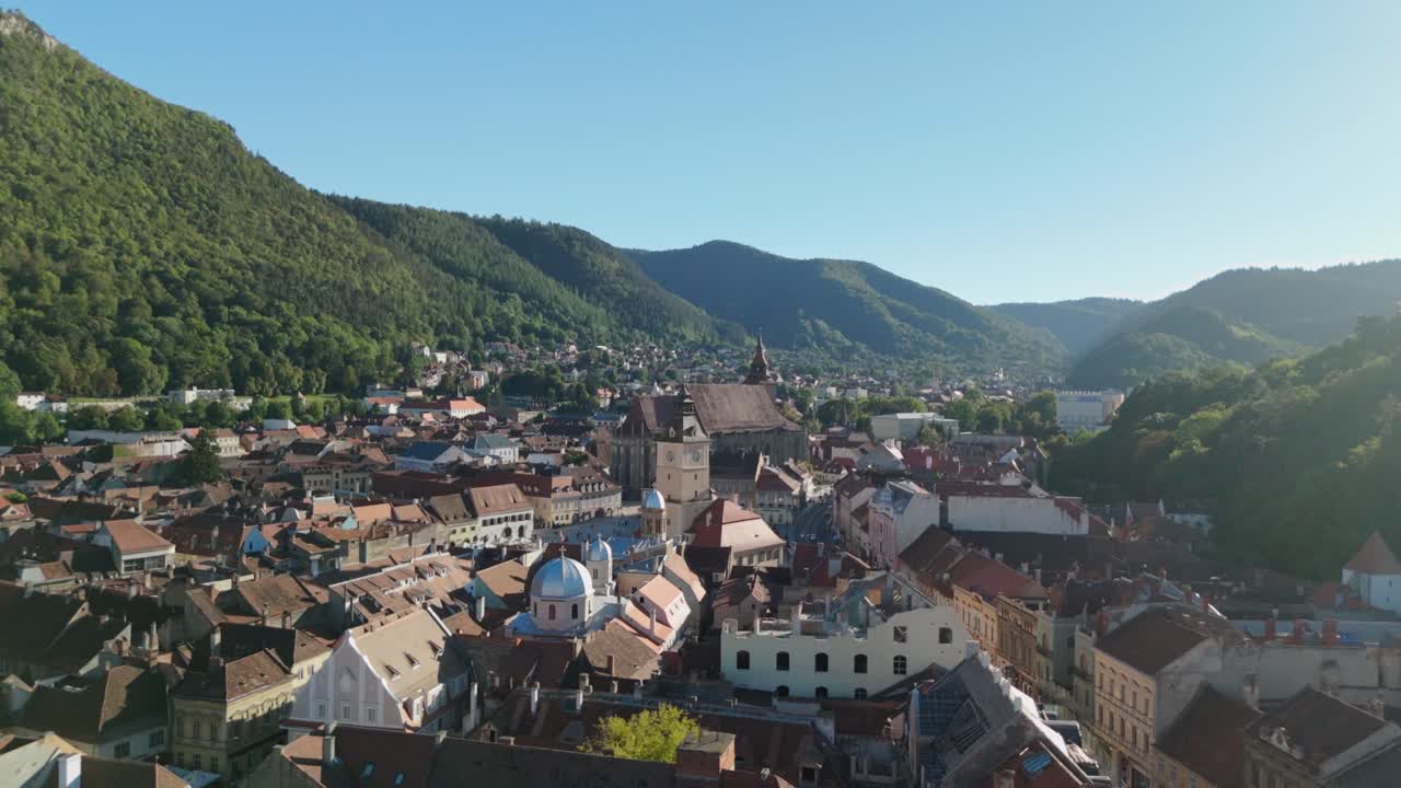 Vista aerea di una città storica circondata da verdi colline in una giornata di sole