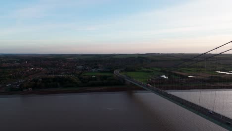 Humber-Bridge-at-dusk,-cars-navigating-gently-under-the-setting-sun