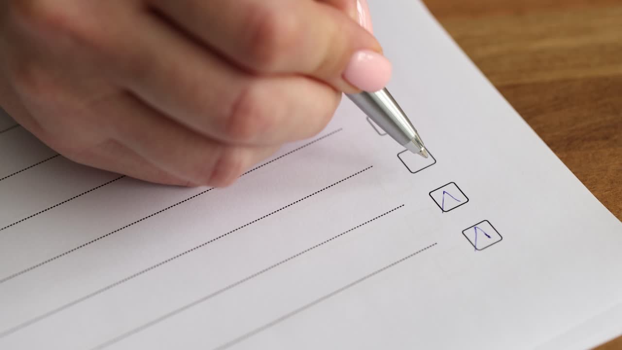 Close-up of Hand Marking Checkboxes on a Document