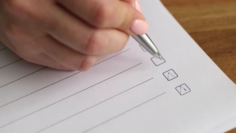 close-up of hand marking checkboxes on a document