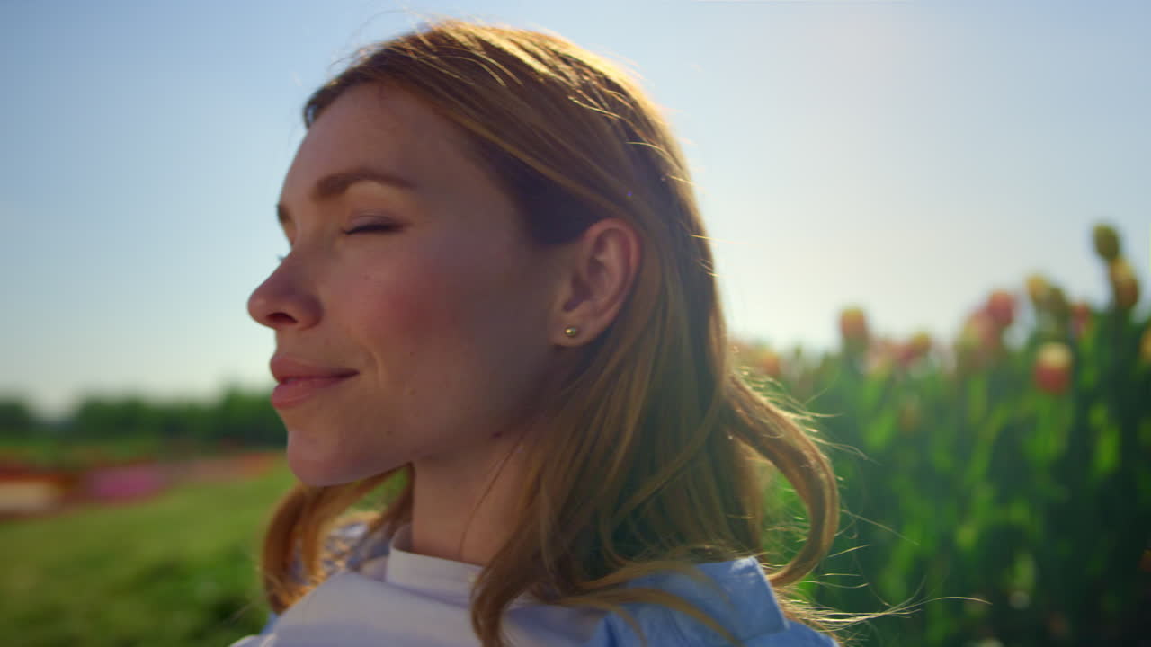 Donna felice che si gode il sole estivo sull'erba verde. Bella donna che chiude gli occhi
