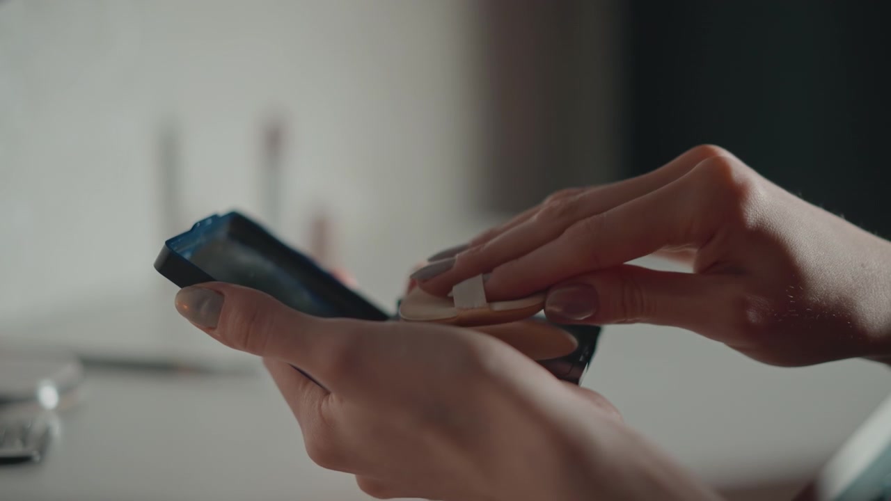 Tight close-up of hands holding smartphone beside bathroom sink, thumb tapping screen with slight phone tilt and soft diffused indoor light creating warm skin tones and shallow depth of field