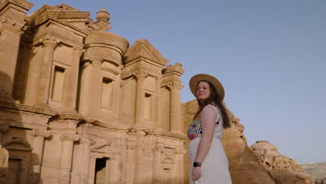 Female-Tourist-Appreciating-The-Ad-Deir-Monastery-In-Petra,-Jordan---Drone-Shot