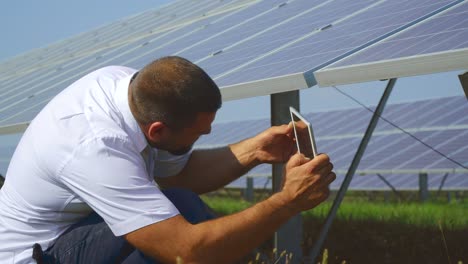 hombre tomando una foto de la parte trasera del panel solar