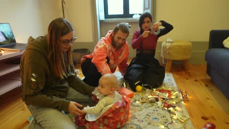 familia desempaquetando regalos de navidad con el bebé