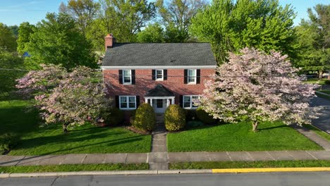 a rising slow cinematic shot of a beautiful colonial style home with a well manicured lawn in america