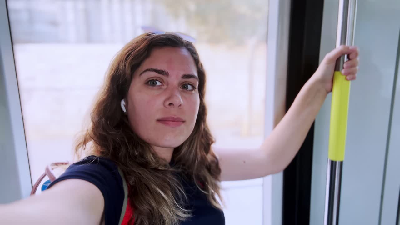 Giovane donna che ascolta musica mentre viaggia su un tram