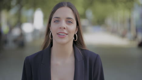 attractive girl walking on street and talking at camera