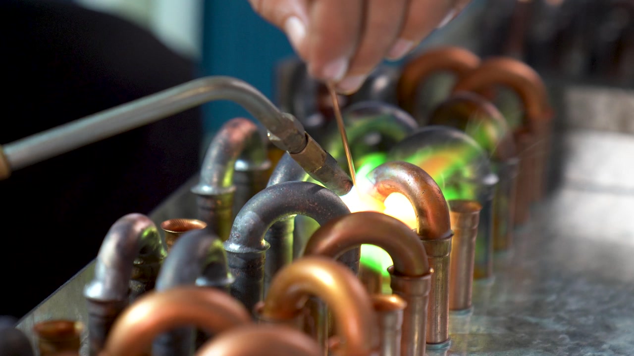 Assembly Of Copper Pipe Joints On The Production Line Using A Blowtorch And Flux, Close Up Shot.