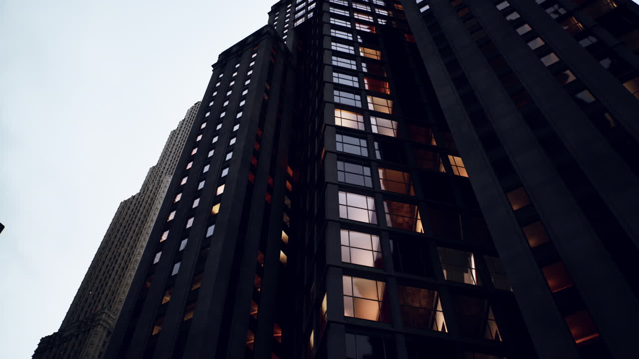 una vista de bajo ángulo de un rascacielos con luces en las ventanas por la noche
